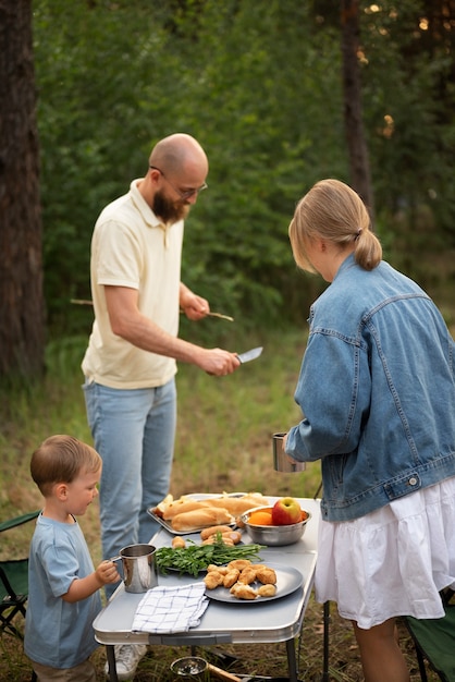 Foto gratuita famiglia che prepara la cena mentre è in campeggio