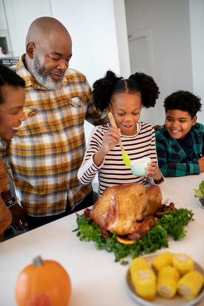 Foto gratuita famiglia che prepara il tacchino del giorno del ringraziamento