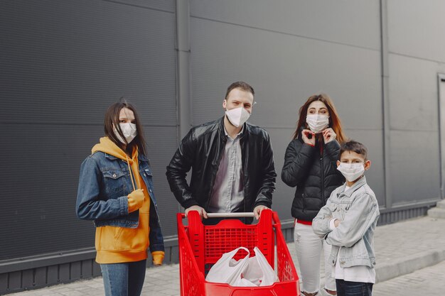 Family in protective masks with purchases