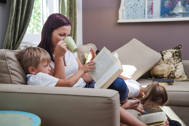 Family relaxing reading books sitting on couch