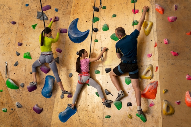 Free photo family rock climbing together indoors at the arena