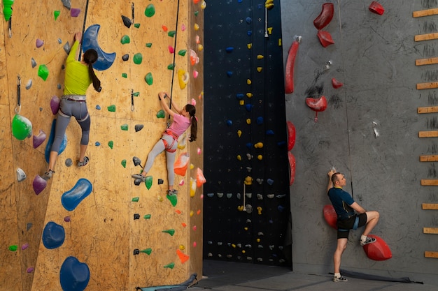 Family rock climbing together indoors at the arena