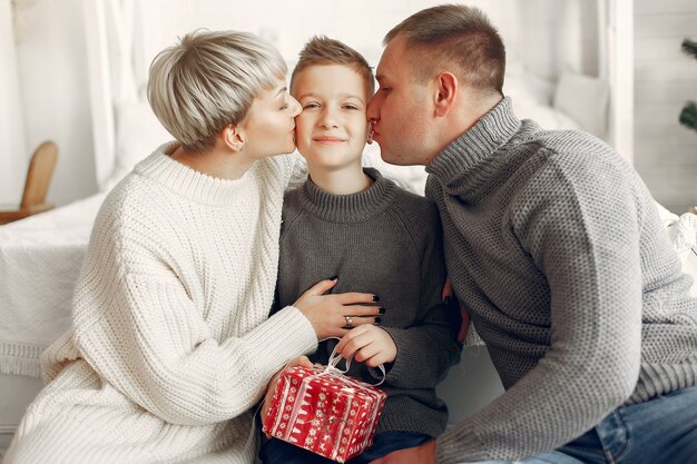 Family in a room. Little boy near christmas decoration. Mother with father with son