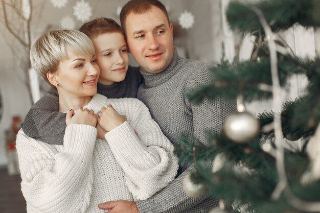 部屋の家族。クリスマスの飾りの近くの小さな男の子。息子と父親を持つ母親