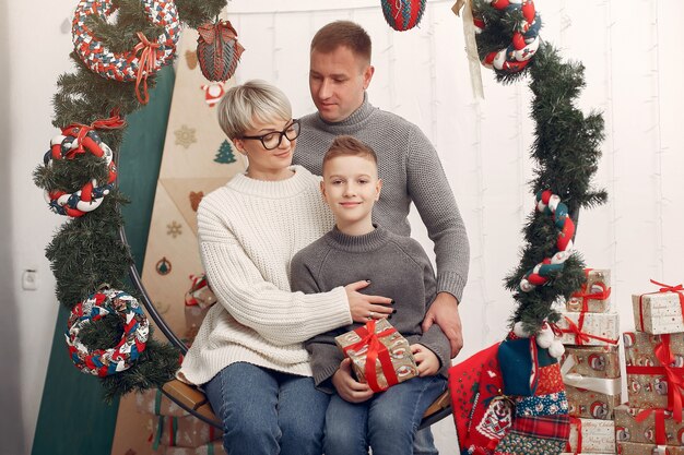 部屋の家族。クリスマスの飾りの近くの小さな男の子。息子と父親を持つ母親