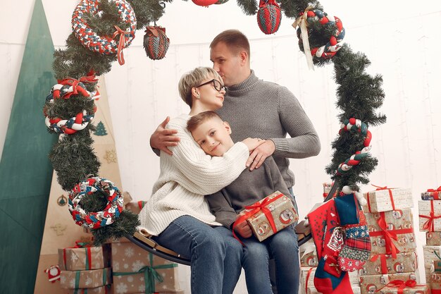 Family in a room. Little boy near christmas decoration. Mother with father with son