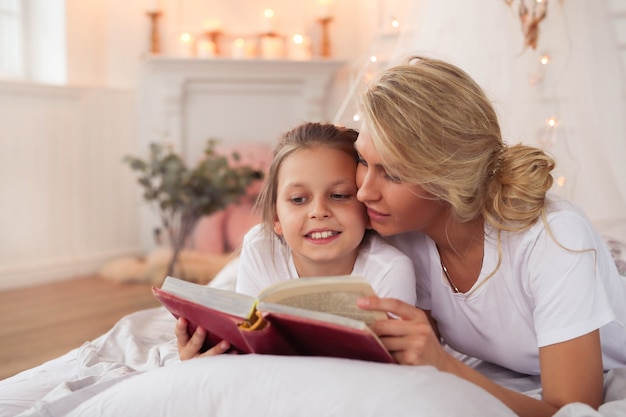 Family scene. Happy mother and daughter in a bed