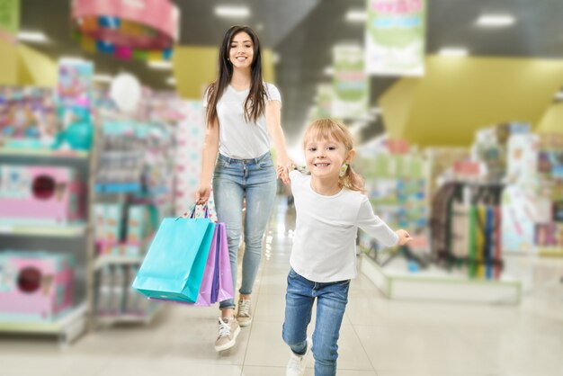 家族の買い物。ショッピングモールを歩く母と子。