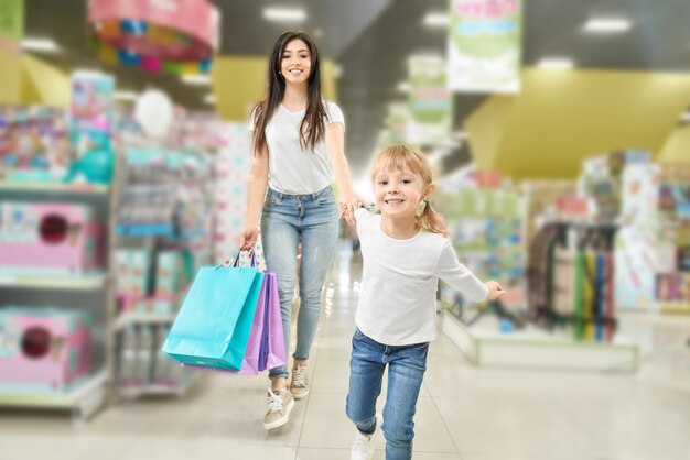 Семейные покупки. Мать и ребенок гуляет в торговом центре.