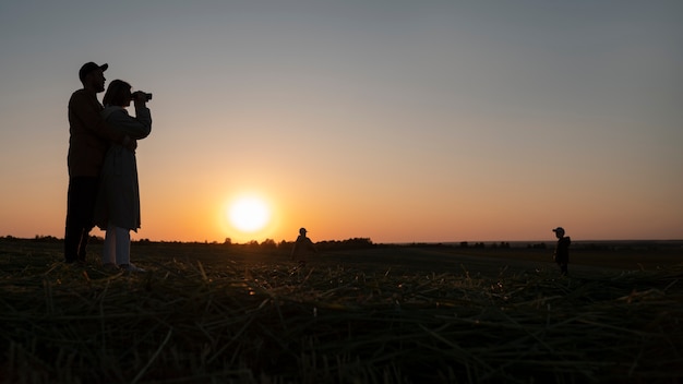 無料写真 夕日のフルショットを楽しんでいる家族のシルエット