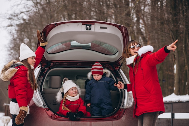 Family sitting in the back of the car outside in winter