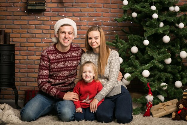 クリスマスツリーに座っている家族