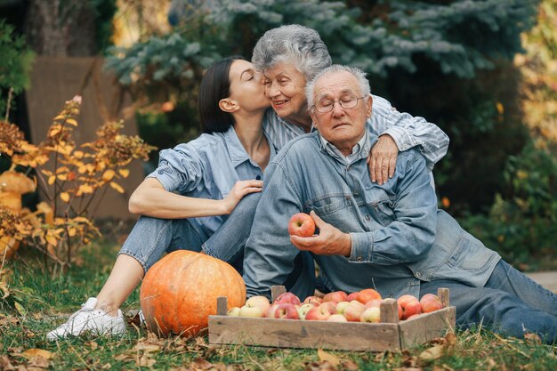 Family sitting in a garden with apples and pumpkin