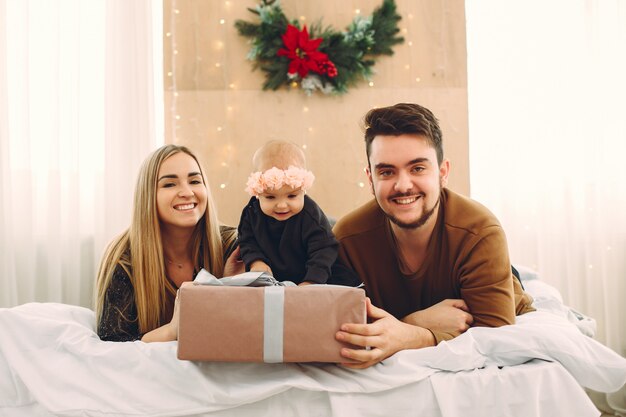 Family sitting at home on a bed with presents