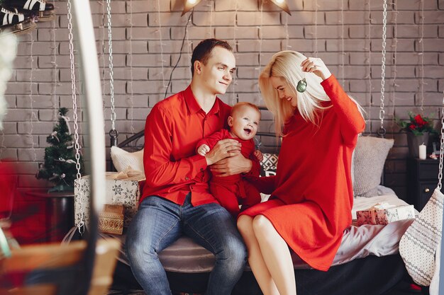 Family sitting at home on a bed