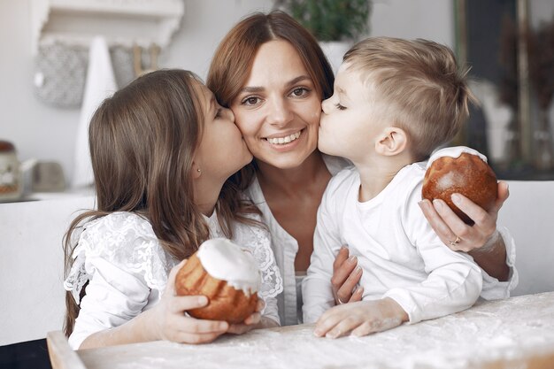 Family sitting in a kitchen and cook the dough for cake