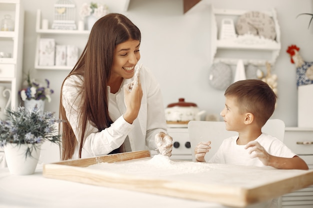 Family sitting in a kitchen and cook the dough for cookies