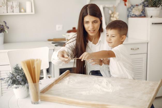 Family sitting in a kitchen and cook the dough for cookies