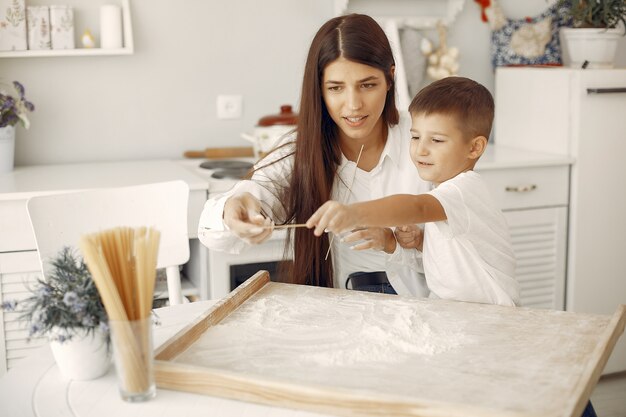 Family sitting in a kitchen and cook the dough for cookies