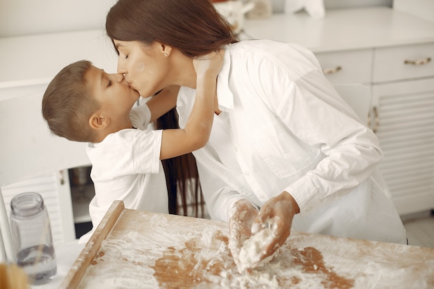 Family sitting in a kitchen and cook the dough for cookies