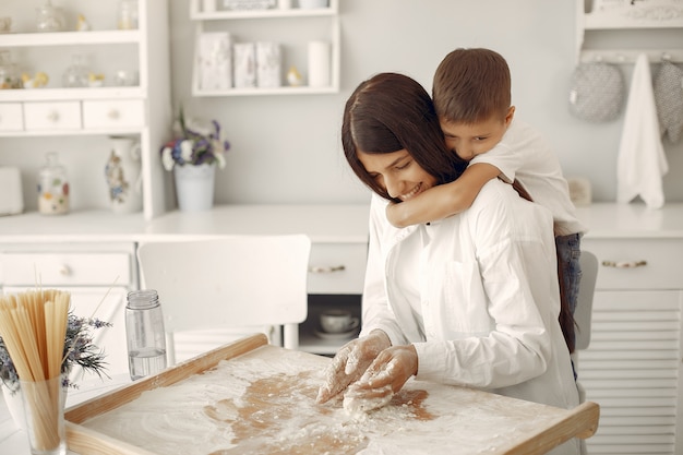 Family sitting in a kitchen and cook the dough for cookies