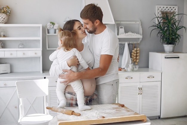 Family sitting in a kitchen and cook the dough for cookies