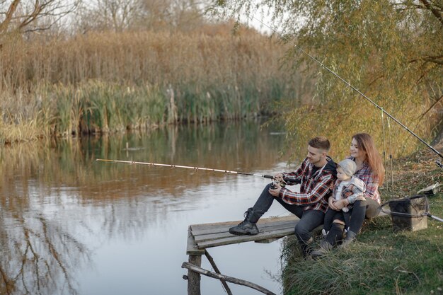 釣りの朝に川の近くに座っている家族