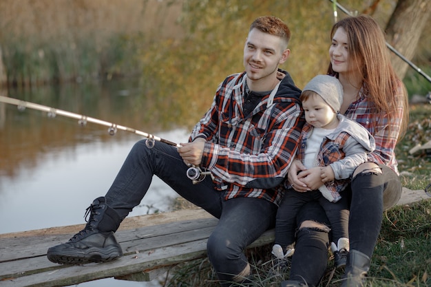 Family sitting near river in a fishing morning