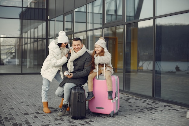 Famiglia seduta all'aperto su un bagaglio e in attesa di viaggiare