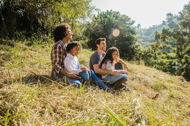 Family sitting on a sunny hill