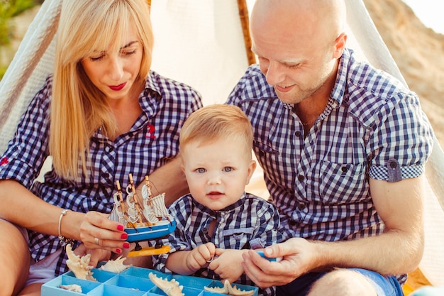 "Family sitting under tent playing. "