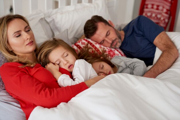 Family sleeping in bed