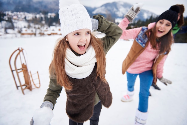 Foto gratuita lotta a palle di neve in famiglia in inverno