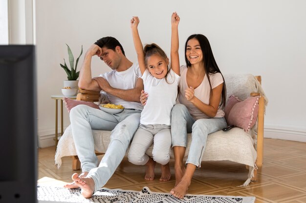 Семья проводит время перед телевизором