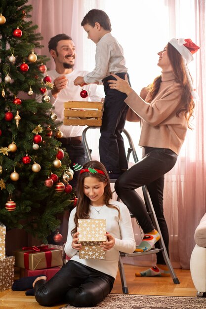 Family spending time together next the christmas tree