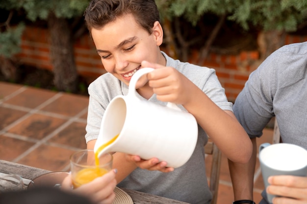 Family spending time together outdoors and drinking orange juice