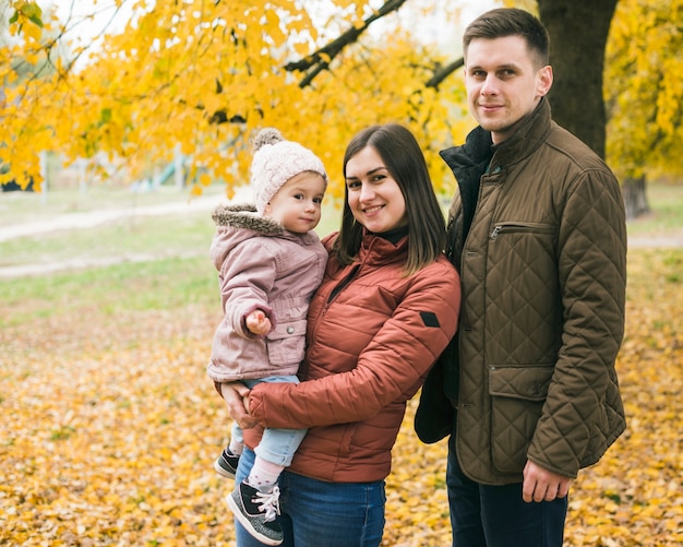 Family standing in autumn park