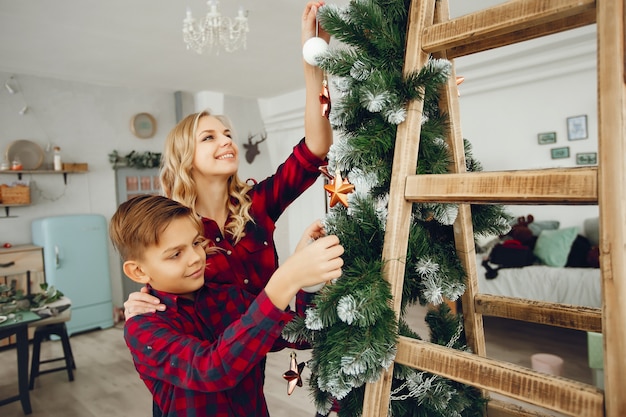 クリスマスツリーの近くに家で家族に立って