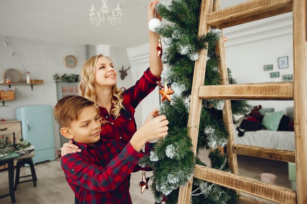 クリスマスツリーの近くに家で家族に立って