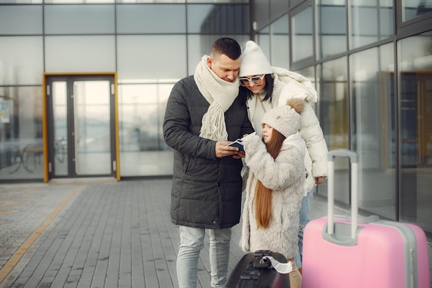 Семья стоит на улице с багажом и проверяет паспорта Premium Фотографии