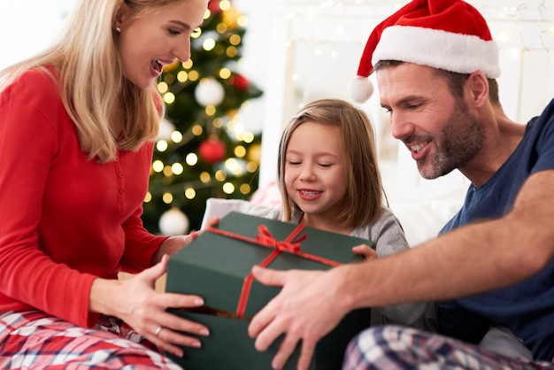 Famiglia che inizia il natale dall'apertura dei regali a letto