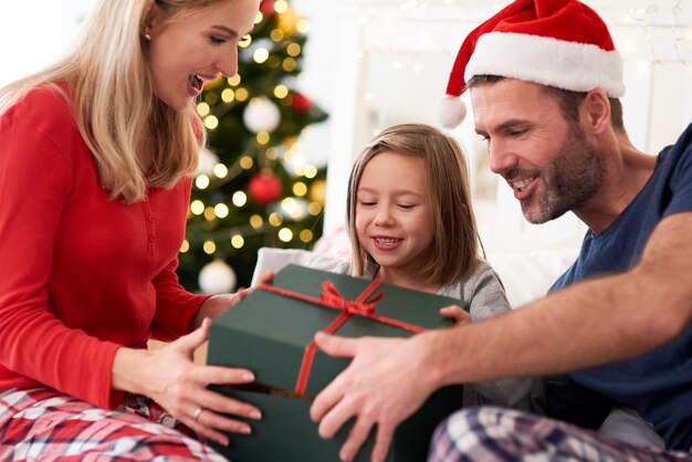 Семья начинает Рождество с открытия подарков в постели