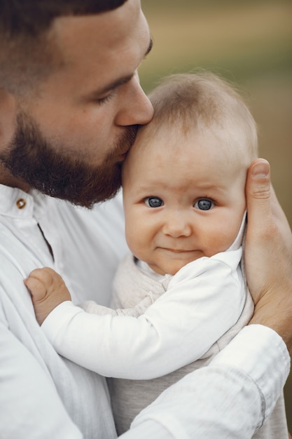 Family in a summer field. Father in a white shirt. Cute newborn daughter.