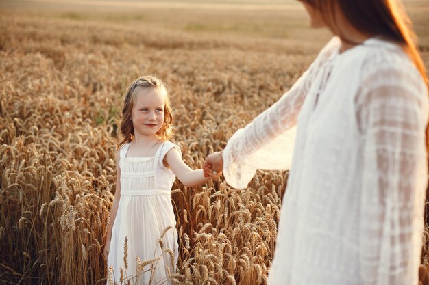 여름 필드에서 가족입니다. 관능적 인 사진. 귀여운 작은 소녀. 흰 드레스에 여자입니다.