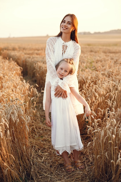 Family in a summer field. Sensual photo. Cute little girl. Woman in a white dress.