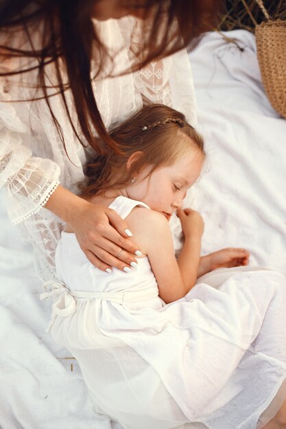 Family in a summer field. Sensual photo. Cute little girl. Woman in a white dress.