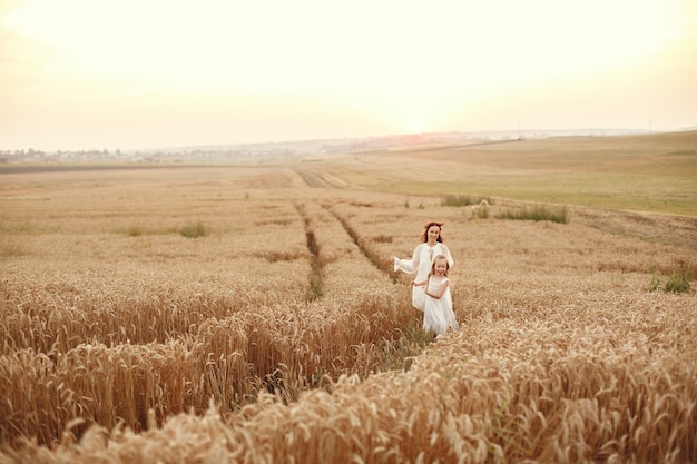 夏の畑で家族。官能的な写真。かわいい女の子。白いドレスを着た女性。