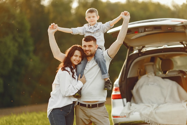 Family in a summer forest by the open trunk