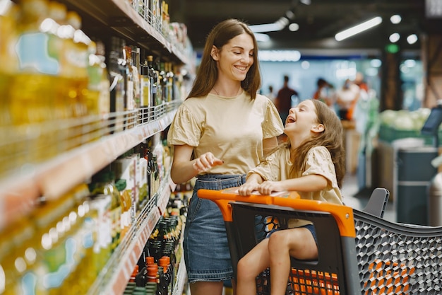 スーパーマーケットの家族。茶色のTシャツを着た女性。人々は製品を選びます。娘と母。