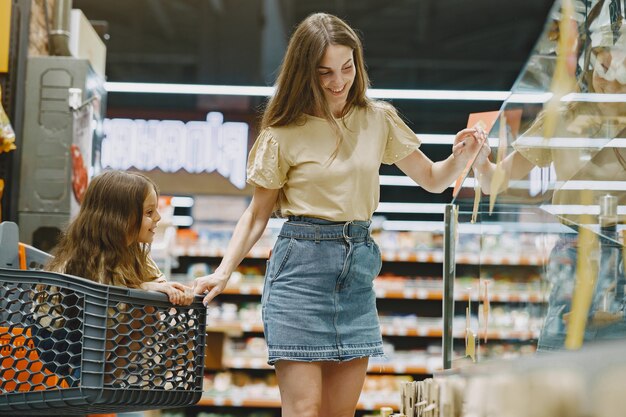 スーパーマーケットの家族。茶色のTシャツを着た女性。人々は製品を選びます。娘と母。
